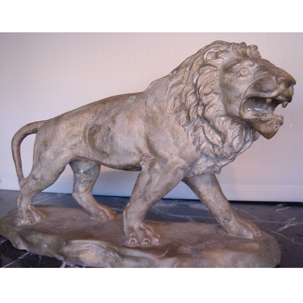 pair of cast metal sculptures of a lion and lioness cast in a bronze